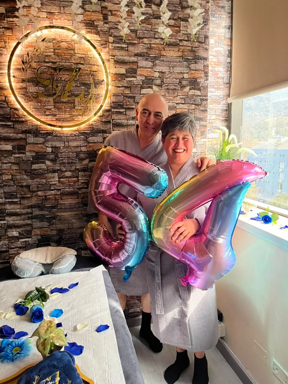 Pareja con globos celebrando en el spa