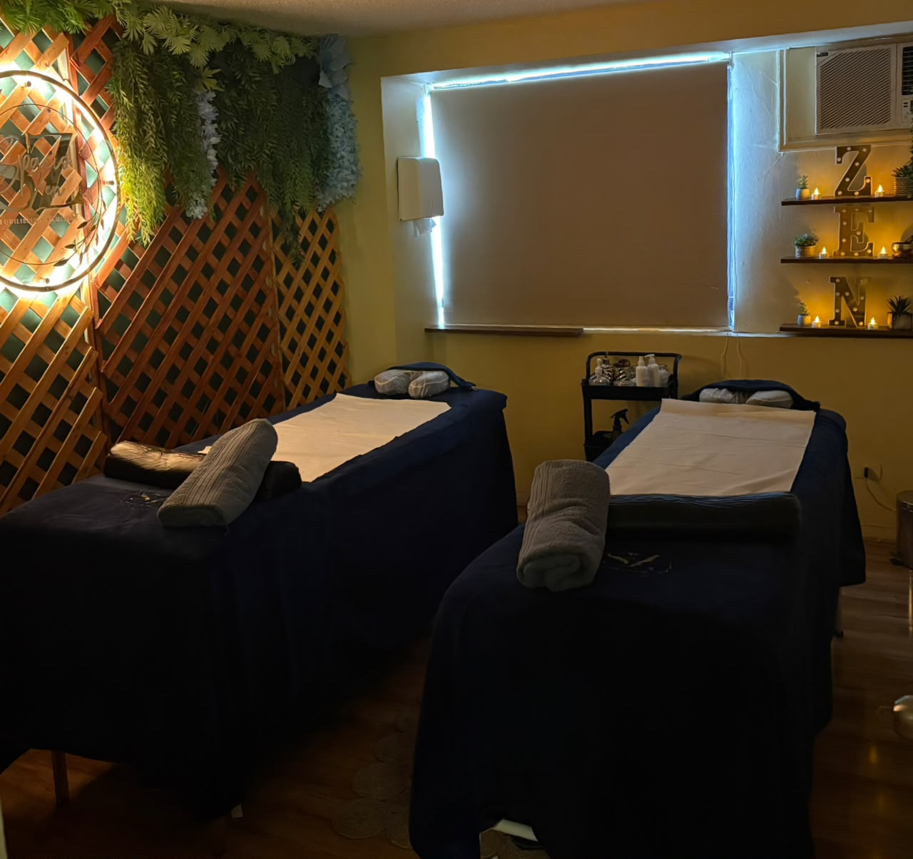 Sala de masajes con techo de flores azules y muro de piedra